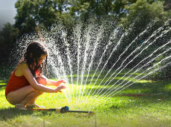 girl playing in sprinkler